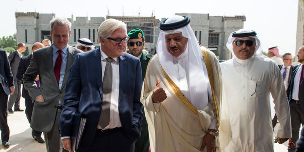 Steinmeier läuft mit dem Generalsekretär des Kooperationsrats der Arabischen Staaten des Golfs, begleitet von Security
