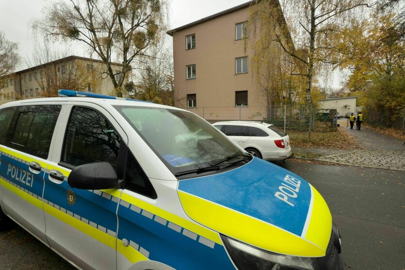 Ein Polizeiauto steht vor einer Flüchtlingsunterkunft