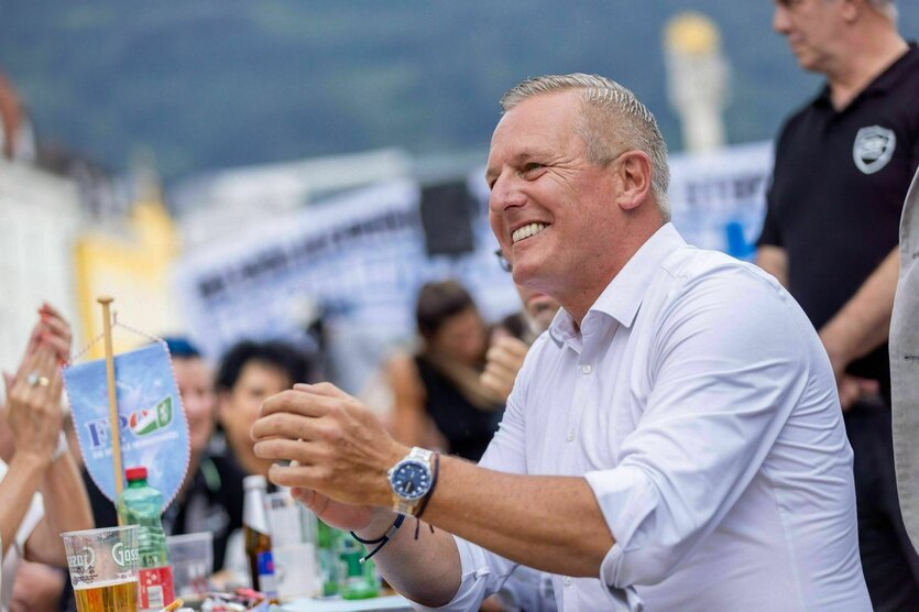 Mario Kunasek FPÖ sitzt an einem Biertisch, lacht und klatscht und hat gute Laune