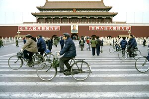 Menschen radeln in den 80er Jahren am Tiananmen Platz mit dem Porträt von Mao, vorbei