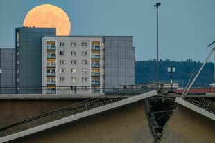 Der Vollmond, auch Supermond genannt, ist am Abend am Himmel über der teileingestürzten Carolabrücke zu sehen