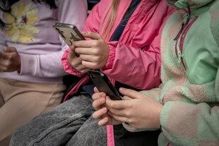 Drei Kinder, Auschnitt auf die Oberkörper, tippen auf ihren Smartphones