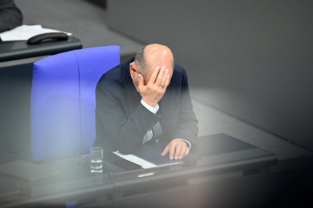 Bundeskanzler Olaf Scholz (SPD) sitzt in der Generaldebatte um den Haushalt 2025 im Bundestag und hat seinen Kopf in die rechte Hand gestützt.