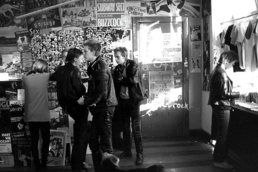 Punks in Lederjacken und Klaus Maeck im Plattenladen "Rip Off" im Hamburger Karoviertel, 1979, an der Wand hinten hängen Buttons