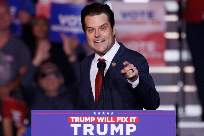 Matt Gaetz spricht an einem Pult mit dem Wahlkampfslogan von Donald Trump