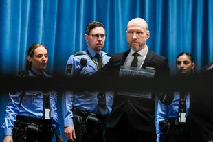 Ein Mann im Vordergrund, dahinter drei Polizist:innen