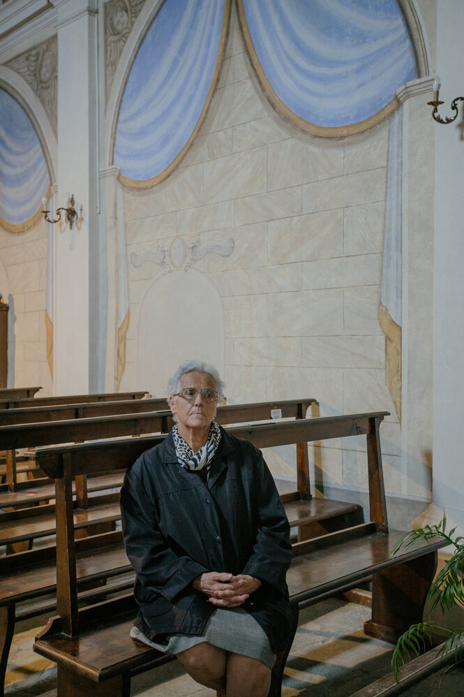 Adele Pardini sitzt auf den Bänken einer Kirche