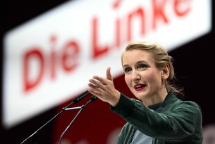 Ines Schwerdtner gestikuliert an einem Rednerpult. Im Hintergrund ist das Logo der Partei "die Linke" zu sehen.