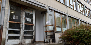 Brandspuren und eine beschädigte Scheibe am Hintereingang einer leerstehenden Schule in Dresden