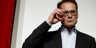 Roger Köppel rückt mit der Hand seine Brille zurecht