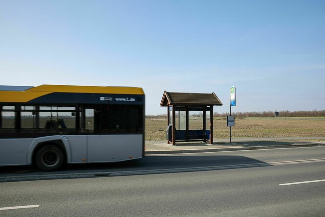 Ein Bus verlässt eine leere Bushaltestelle am Stadtrand von Leipzig