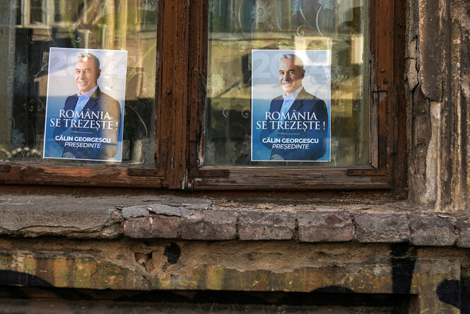 Wahlplakate des rumänischen Präsidentschaftskandidaten Calin Georgescu in Fenstern eines Wohnhauses in Bukarest