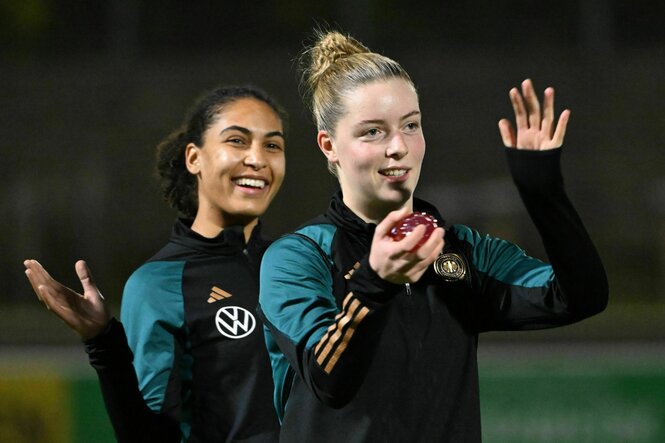 Zicai und Şehitler laufen lächelnd im Trainingsanzug auf den Platz