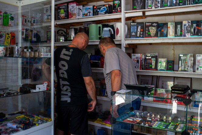 Zwei Personen in einem Laden von hinten fotografiert.