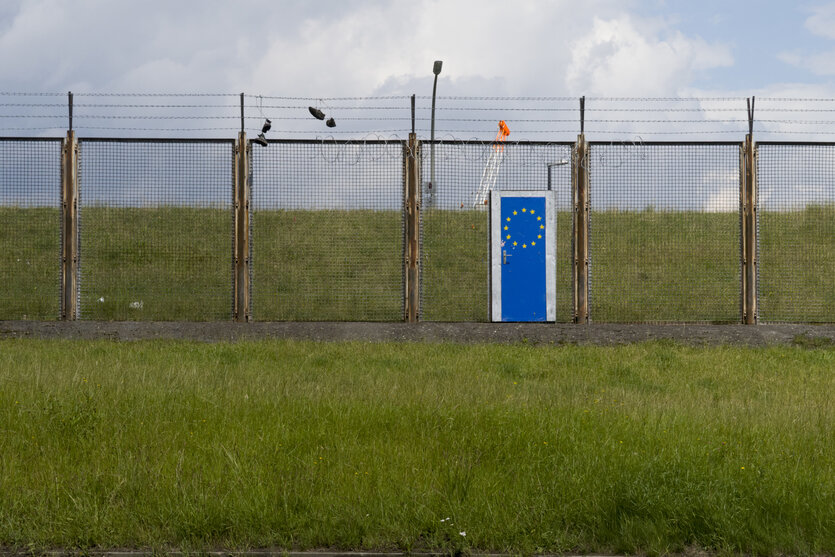 Ein Zaun mit einer blauen Tür