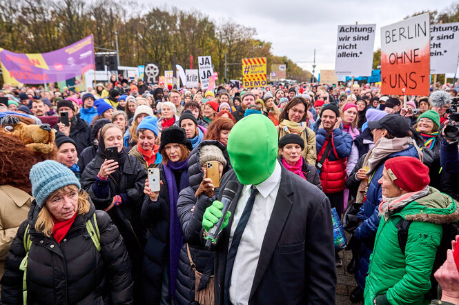 Ein Mann mit grüner Maske auf einer Demo: Performance von Lars Eidinger: ?Das Kostüm soll symbolisieren, was passiert, wenn der Schauspieler nicht mehr da ist?