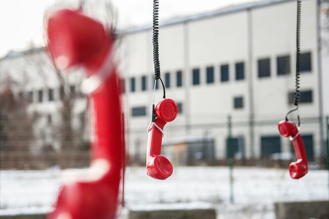 Rote Telefonhörer hängen in der Luft