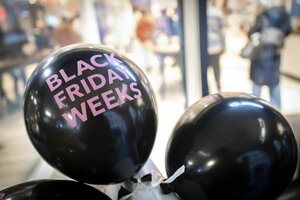 Aufblasbare Ballons, die den Black Friday bewerben, kleben vor einem Geschäft