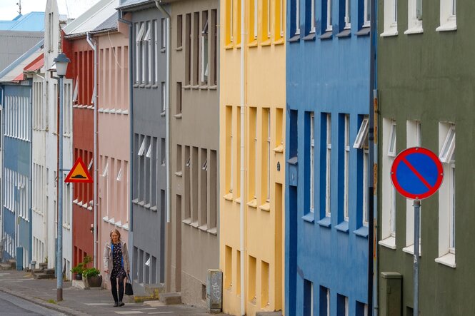 Bunte zweistöckige Häuser stehen an einer steilen Straße