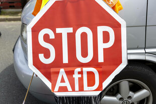 Ein Protestschild, auf dem steht: „STOP AfD“