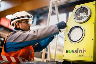 Ein Mann mit Schutzhelm und Schuzbrille bei der Arbeit