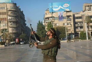 Ein syrischer Oppositionskämpfer schießt in die Luft in der Innenstadt von Aleppo.