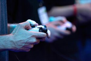 Ein junger Mann hält einen Controller in der Hand