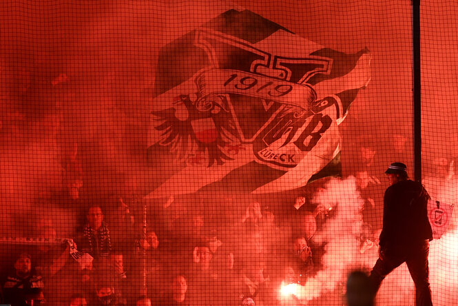 Im Dietmar-Scholze-Stadion an der Lohmühle brennen Lübecker Fans Pyrotechnik ab.