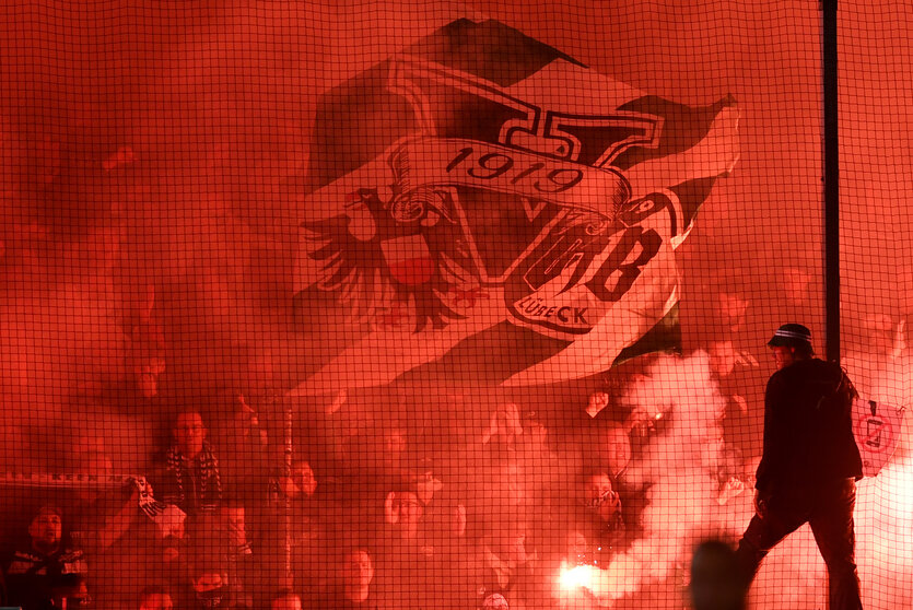 Im Dietmar-Scholze-Stadion an der Lohmühle brennen Lübecker Fans Pyrotechnik ab.