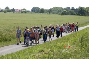 Kinder wandern durch eine Wiese bei einem Klassenausflug