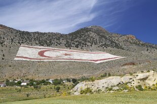 Eine riesiege Flagge Nordzyperns ist auf einem Berg zu sehen