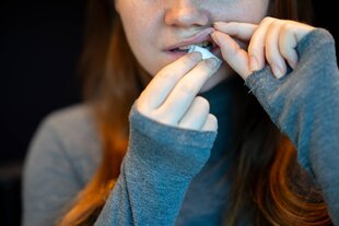 Junge Frau platziert Snus unter der Lippe.