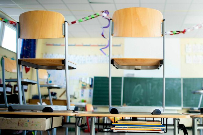 Stühle stehen nach Schulschluss auf den Tischen in einem Unterrichtsraum einer Grundschule.