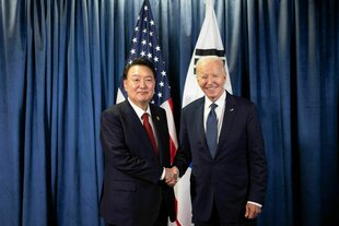 Südkoreas Präsident Yoon Suk Yeol (l) schüttelt die Hand von US-Präsident Joe Biden