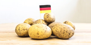 Eine Deutschlandfahne steckt in einem Berg Kartoffeln