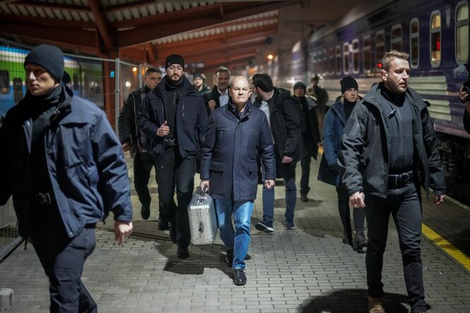 Scholz umgeben von Sicherheitskräften auf einem Bahnsteig