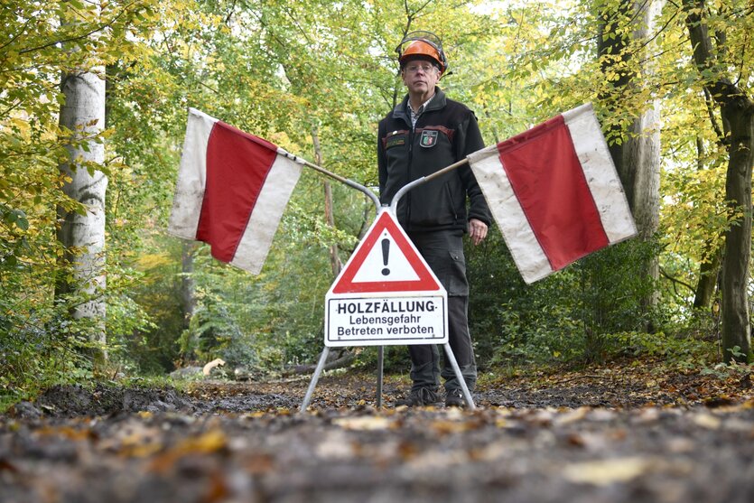 Ein Forstarbeiter sperrt einen Waldweg.