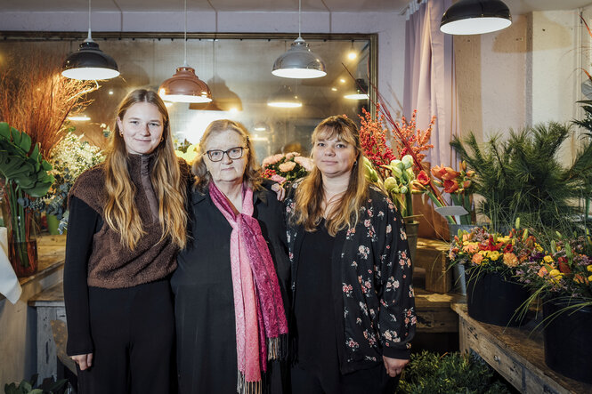 Drei Frauen stehen in einem Blumengeschäft