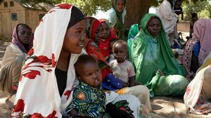 Frauen sitzen mit ihren Kindern auf dem Boden