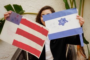 Eine Frau hält eine amerikanische und eine israelische gemalte Flagge in der Hand