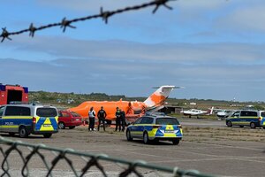 Polizei steht an einem orange angesprühten Privatflugzeug auf einem Rollfeld