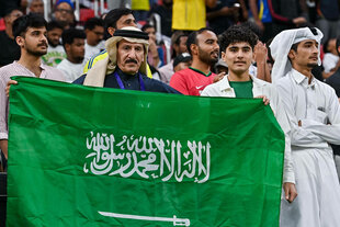 Fans auf der Tribüne halten die Flagge von Saudi-Arabien