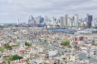 Blick auf die Skyline von Buenos Aires, vorne eine Bundesstraße und die Wohnhäuser eines Slums