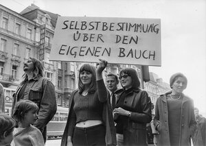 Selbstbestimmunjg über den Eigenen Bauch steht auf einem Plakat, das von einer Frau gehalten wird