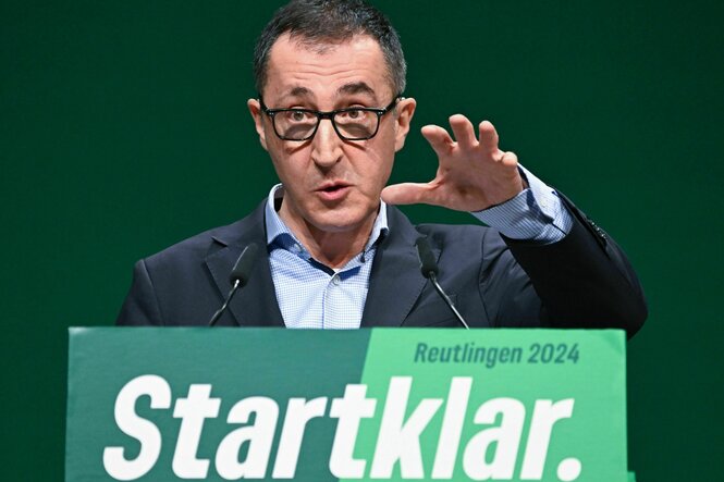 Cem Özdemir steht an einem Rednerpult, an dem "Startklar" steht, und spricht Richtung Kamera.