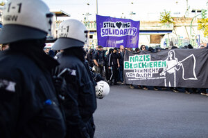 Polizisten beobachten eine Antifa-Demo mit dem Transparent 