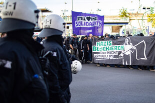 Polizisten beobachten eine Antifa-Demo mit dem Transparent "Nazis blockieren"