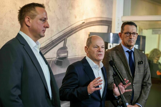 Benjamin Gruschka (l-r), Betriebsratschef Ford Deutschland, Bundeskanzler Olaf Scholz (SPD) und Marcus Wassenberg, Geschäftsführer der Ford Werke, sprechen am Rande der Betriebsversammlung mit Medienvertretern