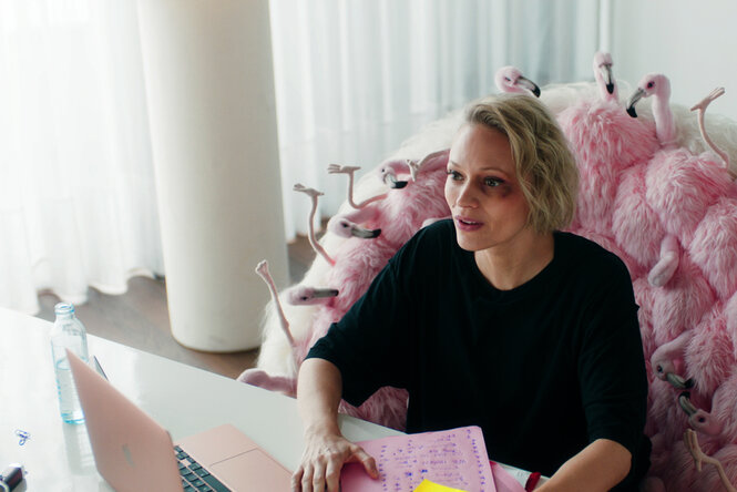 Bundes­kanzlerin Sarah Bedford (Mavie Hörbiger) sitzt in ihrem Büro auf einem rosa Sessel.