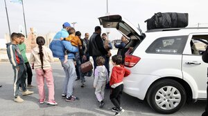 Menschen laden Gepäck in den Kofferraum eines Autos